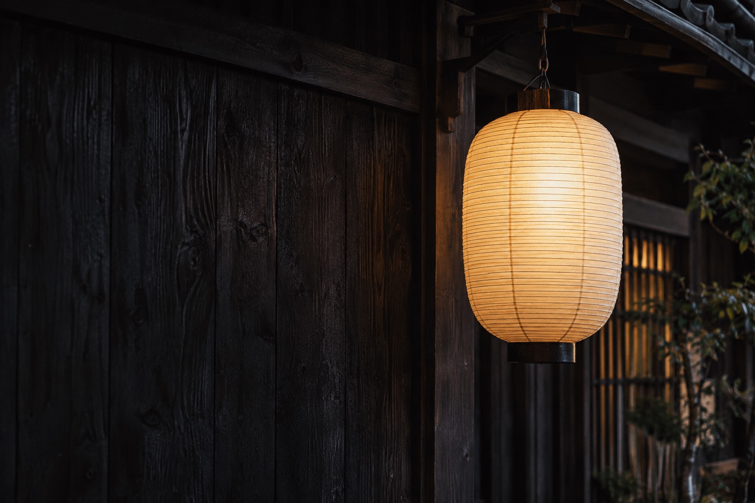 A glowing paper lantern outside a Japanese wooden shop